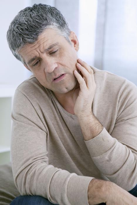 Man holding jaw from pain 