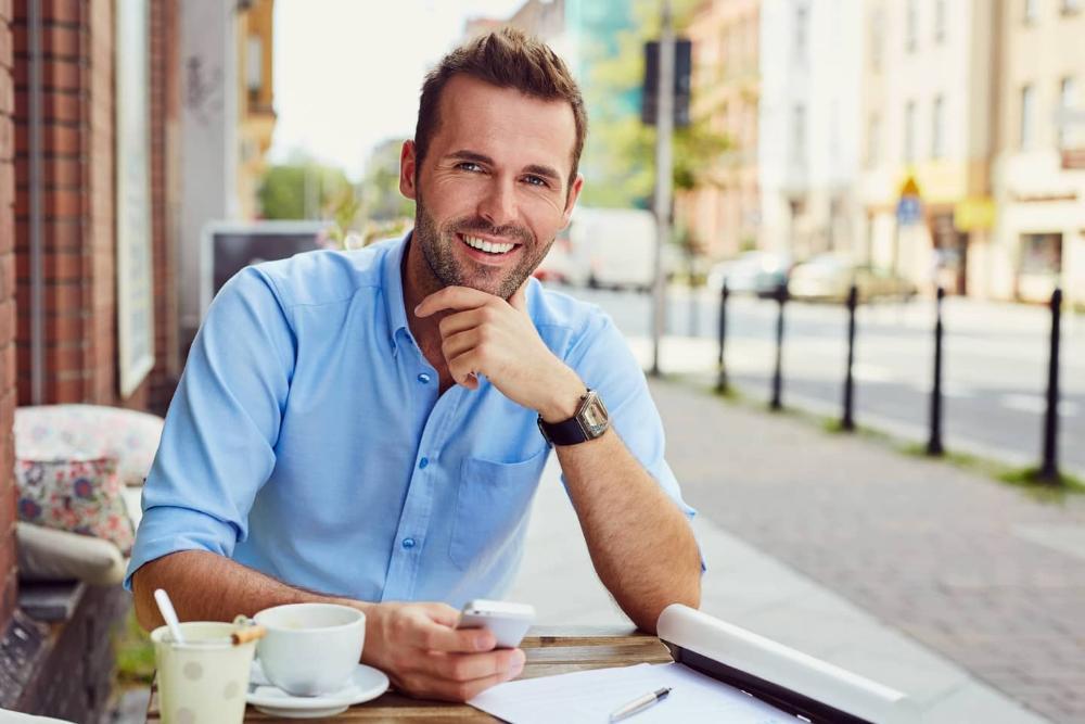 man smiling while sitting outside in a cafe in barrie