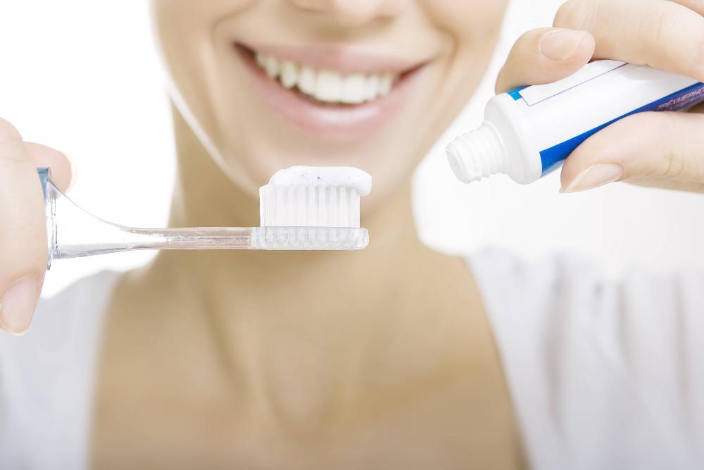 close up of woman holding toothbrush and toothpaste in barrie on