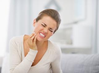 woman holding jaw while in pain from infected tooth in barrie