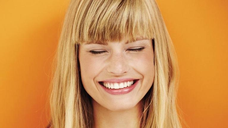 Woman smiling after getting dental fillings