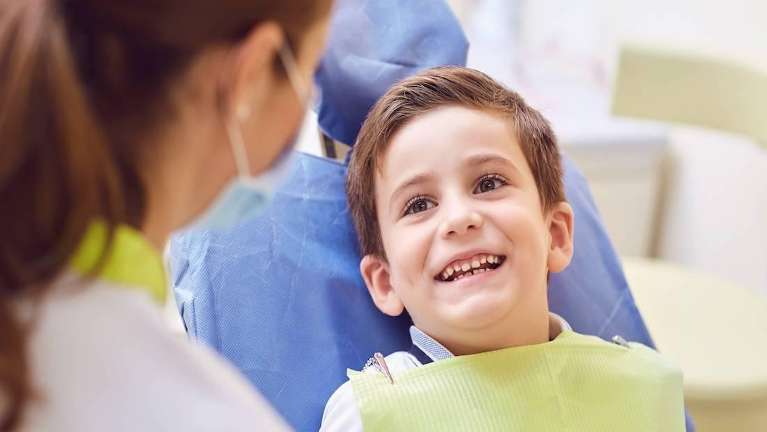 young boy smiling sitting in the dental chair in barrie