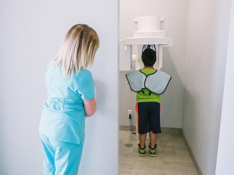 Young boy getting x-rays taken by panoramic x-ray machine